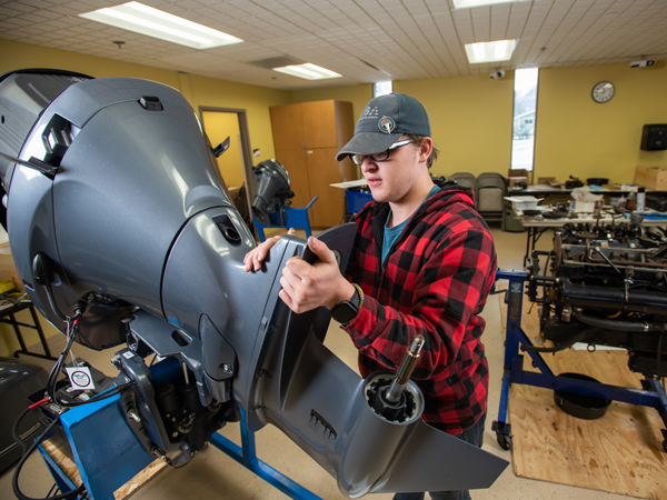 PWSC Marine Services Technology student working on a outboard motor in the classroom in Valdez, Alaska