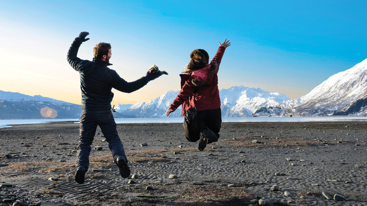 Prince William Sound College students jump on a beach and writes in Valdez, Alaska