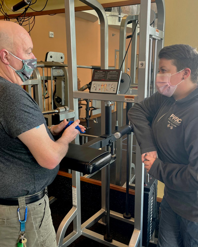 PWSC Health and Fitness Center Coordinator Erin Hickock coaches George Keeny at the gym