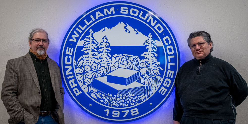 Prince William Sound College professors on campus infront of the blue emblem