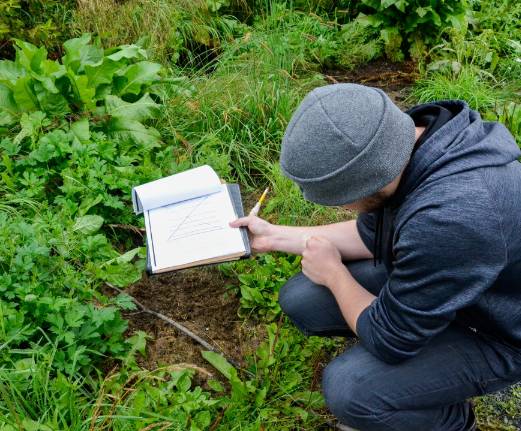 student with notebook observing plantlife