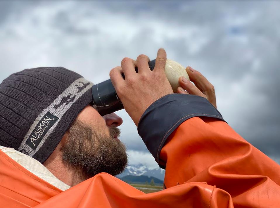 student outdoors observing egg