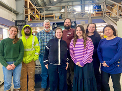 Group photo of eight Office of Administrative Services and maintenance staff members standing together and posing.