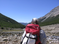A graduate in the field facing toward the mountains. 
