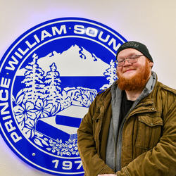 Man in front of college sign.