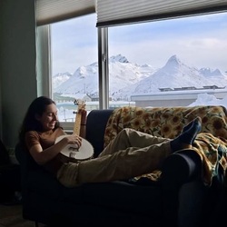 Girl on a couch playing a banjo.