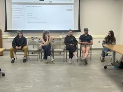 Five interns seated during a class presentation. 