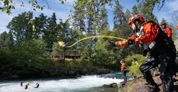 Instructor casting a rope to rescue student in water. 