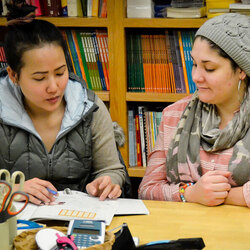 Two students studying from a workbook