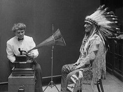 Early anthropologist recording oral histories with a Native American. 