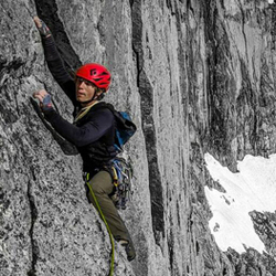 Mountain climber along the side of a rock face, climbing