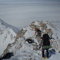 Two climbers climbing on a snowy mountain.