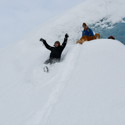 One person sliding down a snow bank.