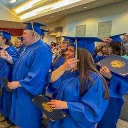 Graduates with caps and gowns on at their commencement.