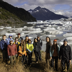 Group of people outside by glacier.