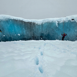 Students practicing crevasse rescue techniques outdoors.