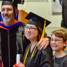 Prince William Sound College dual-credit student Emily Humphrey stands with her family during graduation