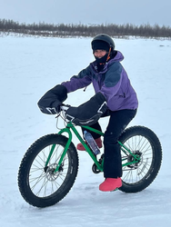 Student on a mountain bike in the snow. 