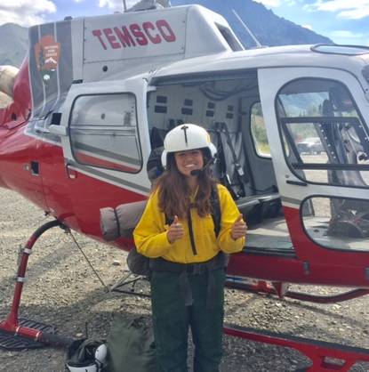 kaylee with thumbs up in front of BLM helicopter