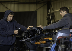 Two students working on an outboard motor.