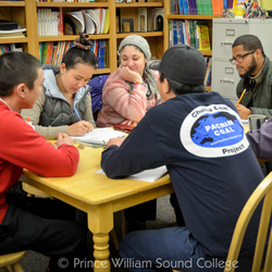 Several students gathered around a table, studying