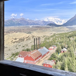 Window view of mountains and buildings.