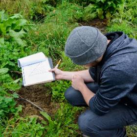 student with notebook observing plantlife