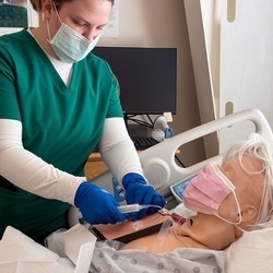 Nursing student working on skills with patient. 