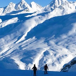 Two hikers in snowy mountains. 