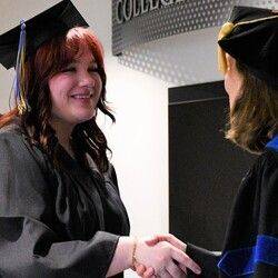 graduate shakes hand with faculty