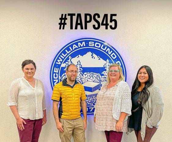staff members in front of PWSC Seal with #Taps45 tag